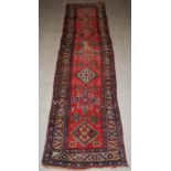A madder ground Persian runner, 20th century, the rectangular field centred with a row of seven