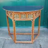 A 20th century bamboo console/ side table, the later painted demi-lune top above an open work