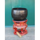 A Chinese red lacquer gong on stand, late 19th/ early 20th century, the gong with a hammered finish,