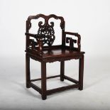 A Chinese dark wood armchair, late Qing Dynasty, the shaped top rail above a carved and pierced