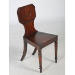 A 19th century mahogany hall chair, the octagonal shaped back above a solid seat, raised on