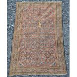 A Persian rug, late 19th/early 20th century, the rectangular madder ground field decorated with