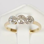 An early 20th century white and yellow metal three stone diamond ring, set with three old cut