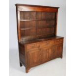 A 19th century oak dresser, the upright back with moulded cornice above three open plate racks, on a