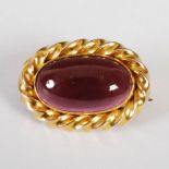 A late 19th century garnet and yellow metal mounted brooch, set with a single carbuncle cabochon cut