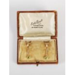 A pair of early 20th century peridot and split pearl yellow metal earrings, single pearl top section