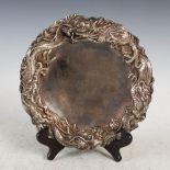 A Japanese silver dragon dish, Meiji Period, the hammered ground with a relief border of dragons