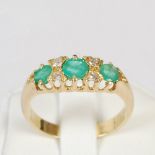 A yellow metal, emerald and diamond seven stone diamond ring, set with a graduated row of three