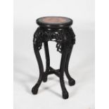 A Chinese dark wood jardiniere stand, Qing Dynasty, the circular top with a mottled red marble