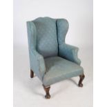 A 19th century mahogany wing armchair, the upholstered back, arms and seat raised on short