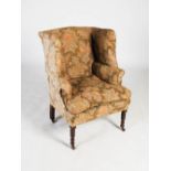 A 19th century mahogany wing armchair, the floral upholstered back, arms and seat with loose