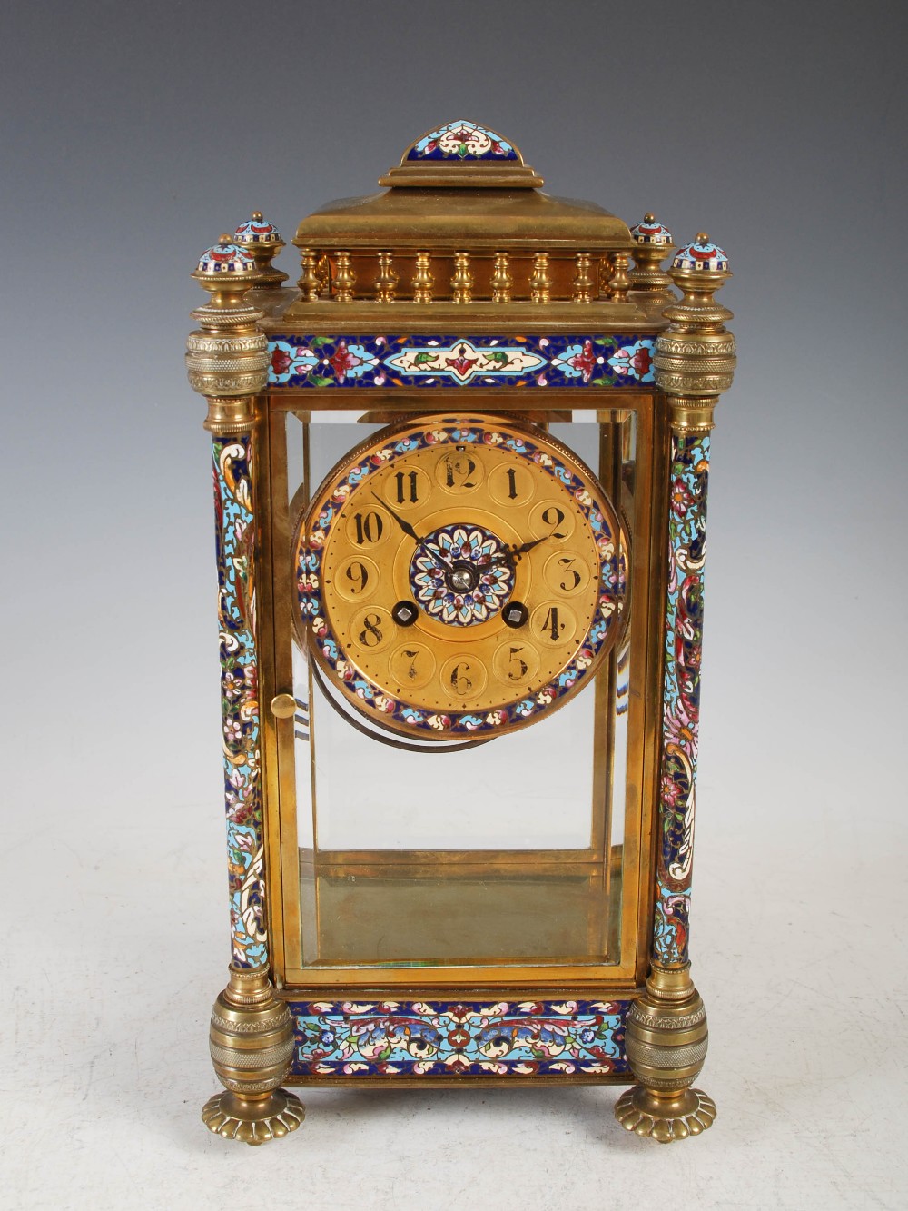 A late 19th/early 20th century gilt metal and champleve enamel mantel clock, the circular dial