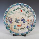 A large Japanese porcelain charger, Meiji Period, decorated in coloured enamels with feasting