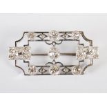 An Art Deco style white metal open panel diamond set brooch, the rectangular panel with canted