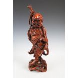 A Chinese carved wood figure of a Sennin, late 19th/early 20th century, with shell inlaid eyes, on