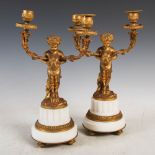 A pair of late 19th century French ormolu and white marble candelabra, modelled with Bacchanalian