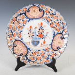 A Japanese Imari charger, Meiji Period, decorated with a central circular panel enclosing urn