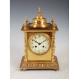 A late 19th/early 20th century gilt metal mantel clock, the circular dial with Arabic numerals and
