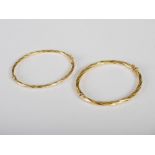 Two yellow metal spiral twist bangles, stamped 750, 12.2 grams.