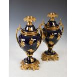 A pair of late 19th century French bleu de roi ground porcelain ormolu mounted paraffin burning