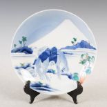 A Japanese Nabeshima porcelain dish, decorated with Mount Fuji, horse and attendant, 21cm diameter.