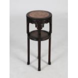 A Chinese dark wood jardiniere stand, Qing Dynasty, the circular top with a mottled red marble