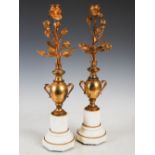 A pair of late 19th century gilt metal and white marble candelabra, formed as a pair of twin handled