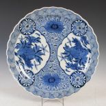A Japanese blue and white porcelain charger, early 20th century, decorated with panels of peony