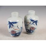 A pair of Chinese porcelain blue, white and copper red vases, bearing Qianlong six character