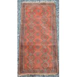 A Persian rug, late 19th/early 20th century, the rectangular madder ground decorated with two rows