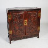 A Chinese dark wood side cabinet, late Qing Dynasty, the rectangular panelled top above a pair of