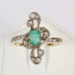 An early 20th century white and yellow metal emerald and diamond set cocktail ring, centred with a