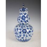 A Chinese blue and white porcelain double gourd vase and cover, Qing Dynasty, decorated with