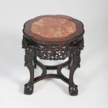 A Chinese dark wood jardiniere stand, Qing Dynasty, the shaped circular top with a mottled red and