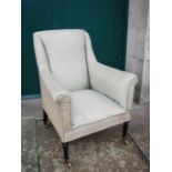 An early 19th century ebonised armchair, the satin upholstered back, arms and seat raised on tapered