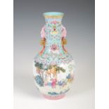 A Chinese porcelain famille rose bottle vase, early 20th century, decorated with figures in a fenced