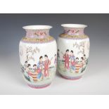 A pair of Chinese porcelain famille rose vases, early 20th century, decorated with ladies in a