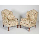 A pair of late 19th/early 20th century mahogany wing armchairs by Howard & Sons, the floral