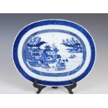 A Chinese blue and white porcelain oval shaped dish, Qing Dynasty, decorated with pavilions and