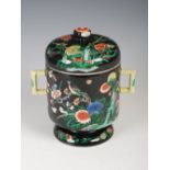 A Chinese porcelain black ground twin handled cup and cover, Qing Dynasty, decorated with birds,