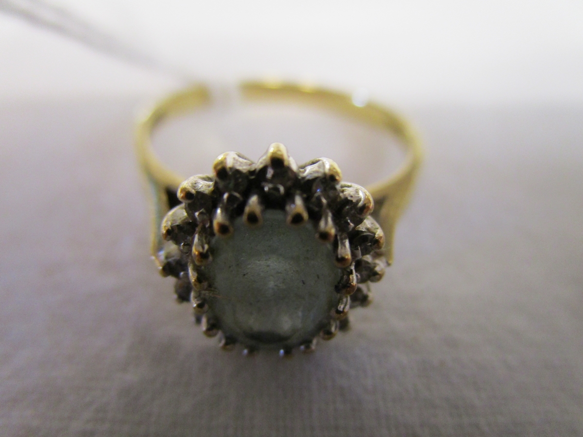 Gold ring set with diamonds and green stone