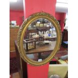 Oval and gilt framed wall mirror