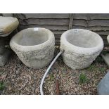 Pair of circular stone planters adorned with roses