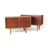 A pair of 1970's teak cabinets with twin sliding doors on tapering legs, w.