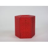 A red perspex lamp shade of hexagonal form