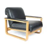 A 1970's oak framed low lounge armchair with black leather armpads and upholstery on a sleigh-type