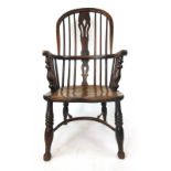 An early 19th century elm Windsor chair, the comb back having a pierced splat on turned legs, h.