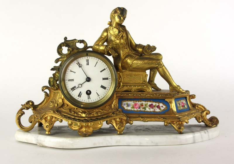 A 19th century French ormolu mantle clock surmounted by a lounging youth over painted ceramic