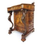 A Victorian burr walnut davenport the galleried top with writing slope lifting to reveal a fitted