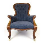 A Victorian mahogany nursing chair upholstered in a blue button back fabric with a serpentine seat